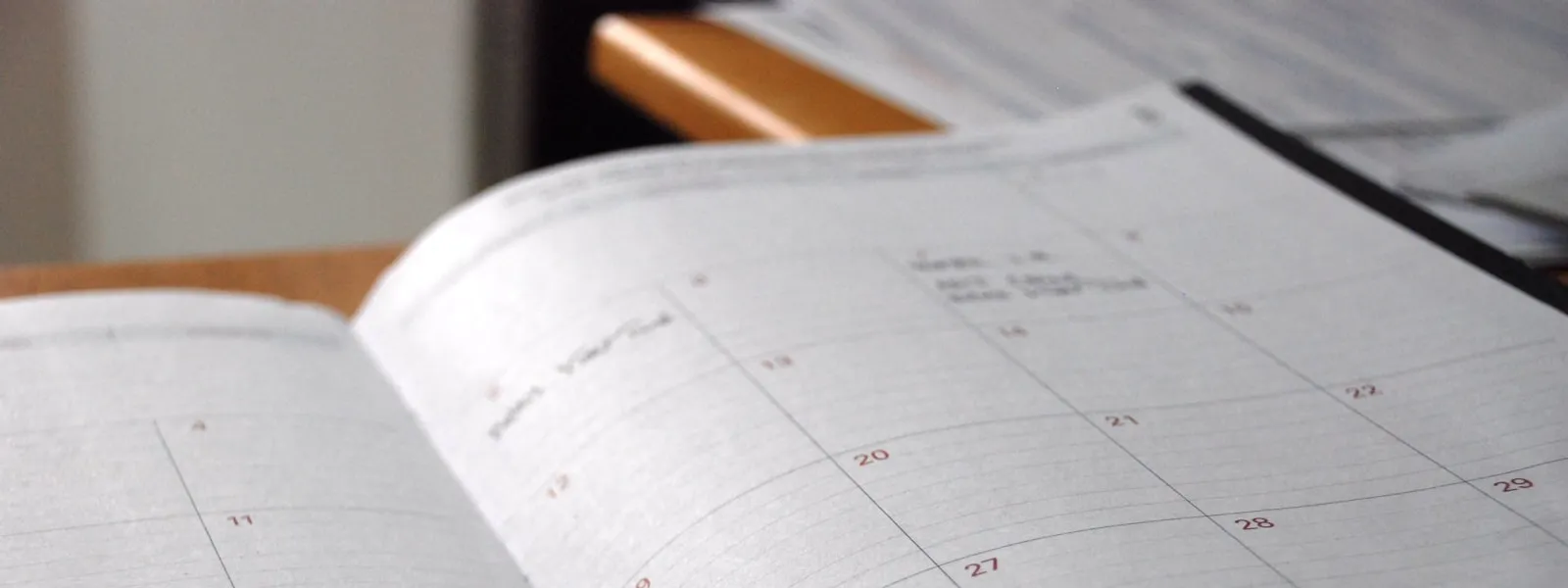 Aufgeschlagener Monatskalender auf dem Tisch — jährliche Verlängerung der LEI-Nummer
